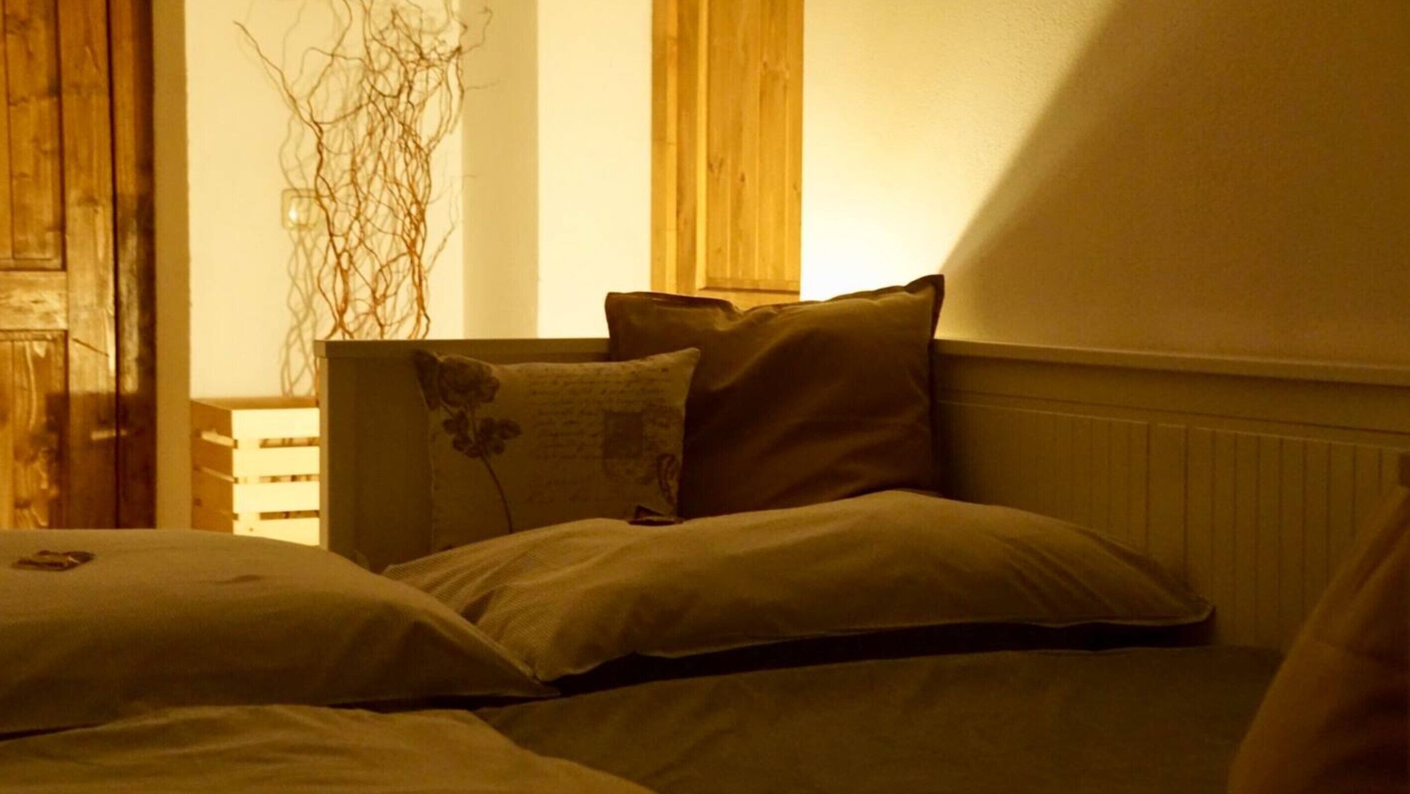 Ein Schlafzimmer mit einem Bett, Kissen, einem Holzkopfende und einer Heizung.
