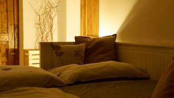 A bedroom with a bed, pillows, a wooden headboard, and a radiator.