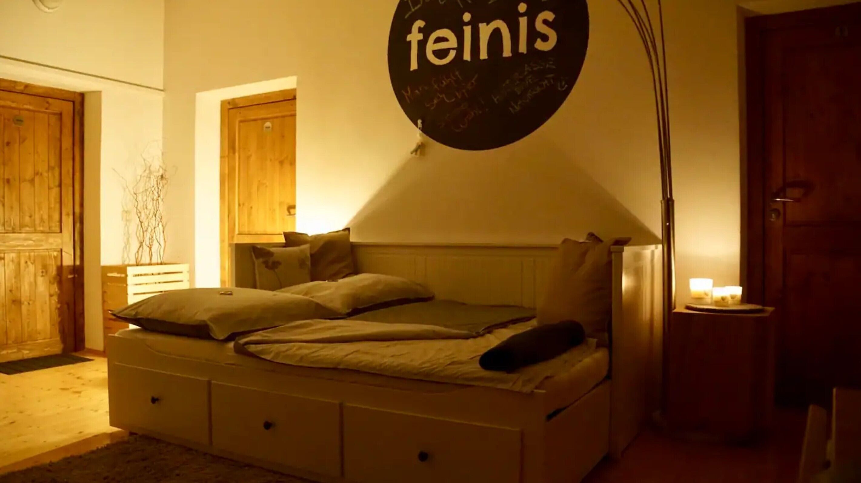 Un dormitorio con una cama, un letrero circular en la pared y puertas de madera.