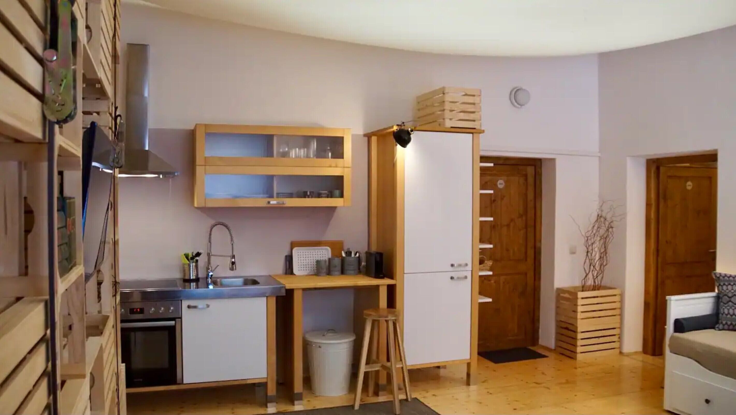 Une cuisine de taille réduite, équipée d’un évier, d’une cuisinière et de meubles de rangement en bois.