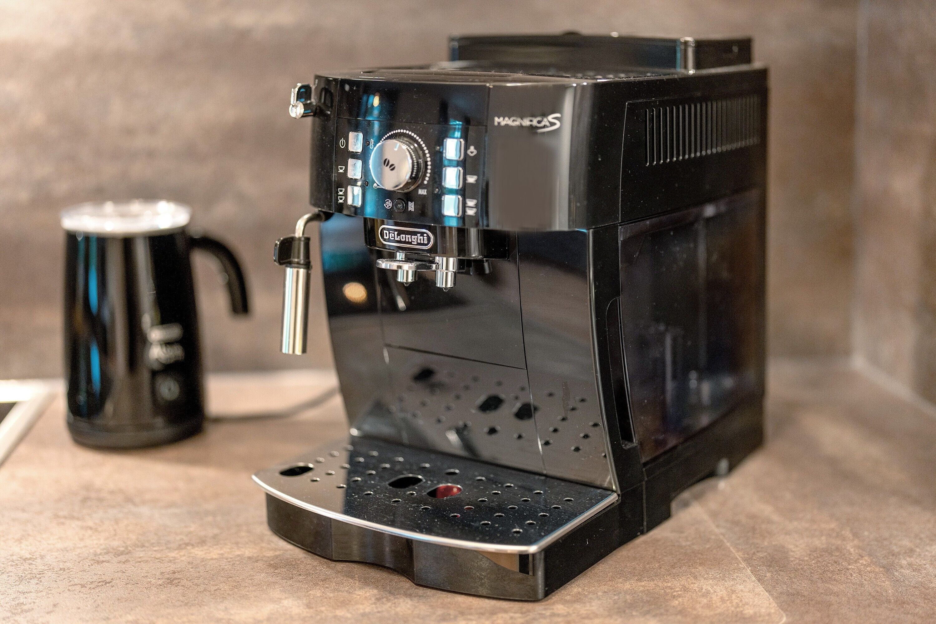 Een koffieapparaat met een bedieningspaneel, een filterhouder en een opvangbak.