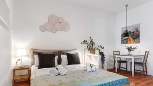 A bedroom with a bed, bedside table, lamp, and a painting on the wall. - Studio Apartment 'Km Style  Nr 1' with Private Terrace and Wi-Fi (Freiburg im Breisgau)