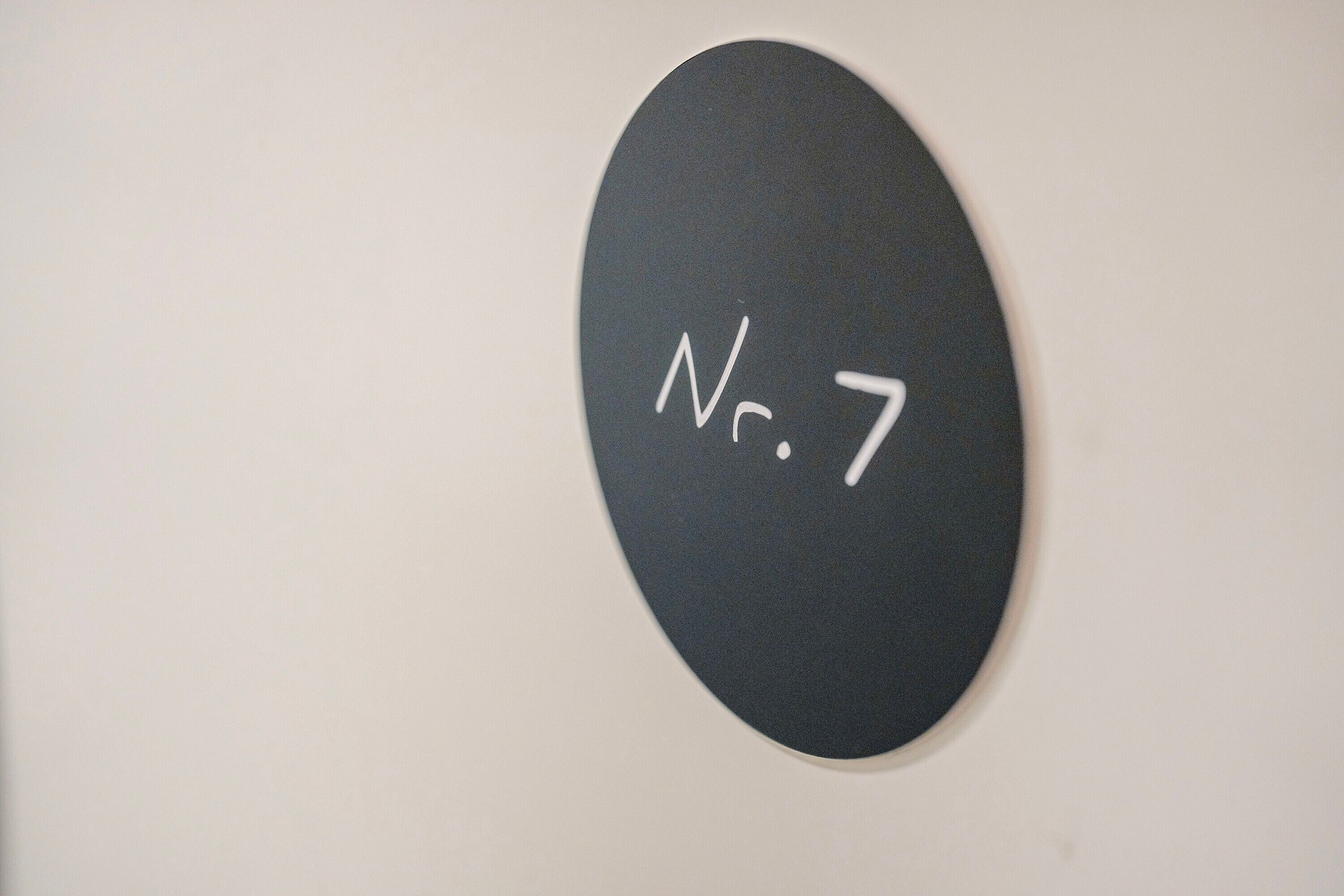 A black oval sign with white text 'No. 7' on a white background.