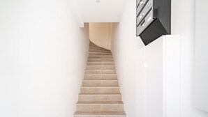 En moderne trappe med et minimalistisk design, hvide vægge og en gulv i neutrale farver.