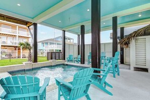 A pool area with turquoise Adirondack chairs and a view of a residential building in the background. - Moon Pye, Pool, Dog Friendly (Crystal Beach)