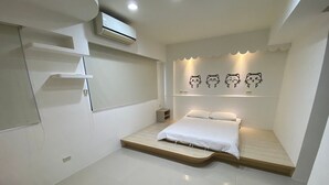 A modern bedroom with a bed, a nightstand, a wall-mounted air conditioner, and a shelf unit. - Friend Homestay (Toucheng)