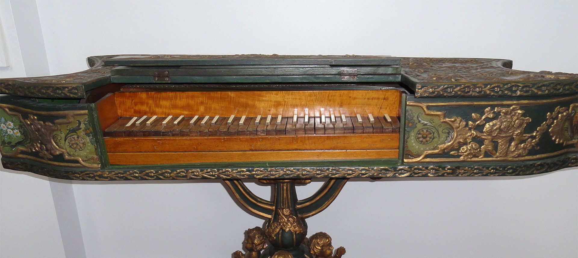 Un piano de madera detallado con tallas intrincadas y una base decorativa.
