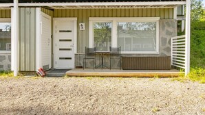 Un bâtiment d’un seul étage, doté d’un porche couvert, d’une porte portant l’inscription « A3 » et d’un petit espace détente avec deux chaises et une table.