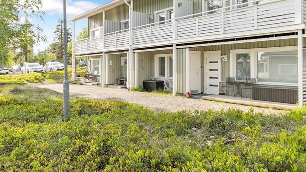 Un motel à deux étages doté d’un espace extérieur abrité avec des sièges et d’une allée en gravier.