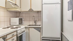 Une cuisine compacte équipée d’un four à micro-ondes, d’une cuisinière, d’un évier et d’un réfrigérateur.