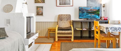 Una habitación acogedora con una cama, una silla, una mesa y un televisor.