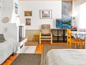 Una habitación acogedora con una cama, una silla, una mesa y un televisor.
