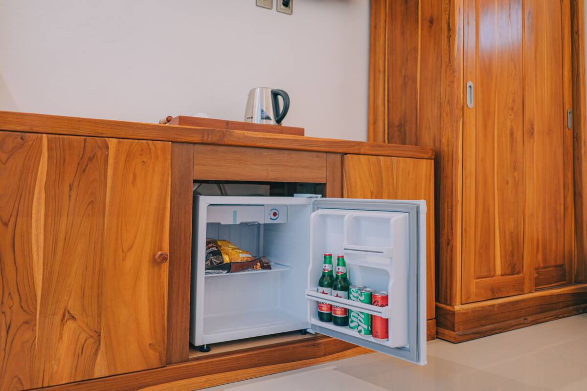 Un refrigerador compacto con un compartimento congelador, un estante y un tirador.