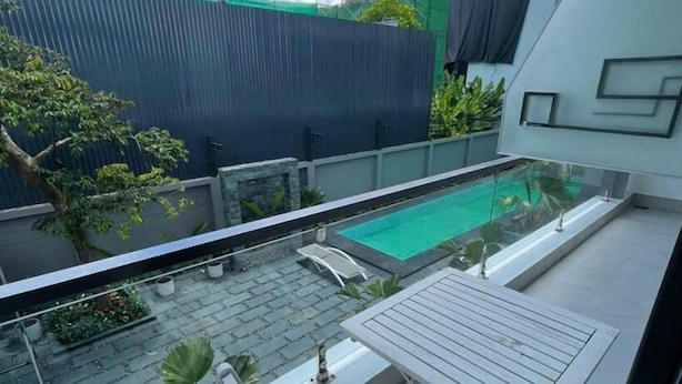 Ein Balkon mit Pool, Tisch und Stühlen.