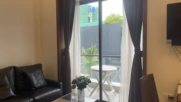 Basic Apartment, Pool View | Living area | Flat-screen TV