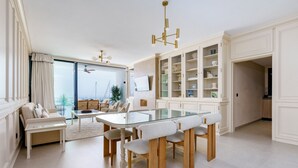 Ein geräumiges Wohnzimmer mit einem Glastisch, einer Couch und Blick aufs Meer.