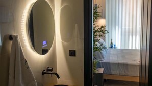 A modern bathroom with a large mirror, a towel rack, and a sink. - Triple a - Chrisospiliotissis 7 (Athens)