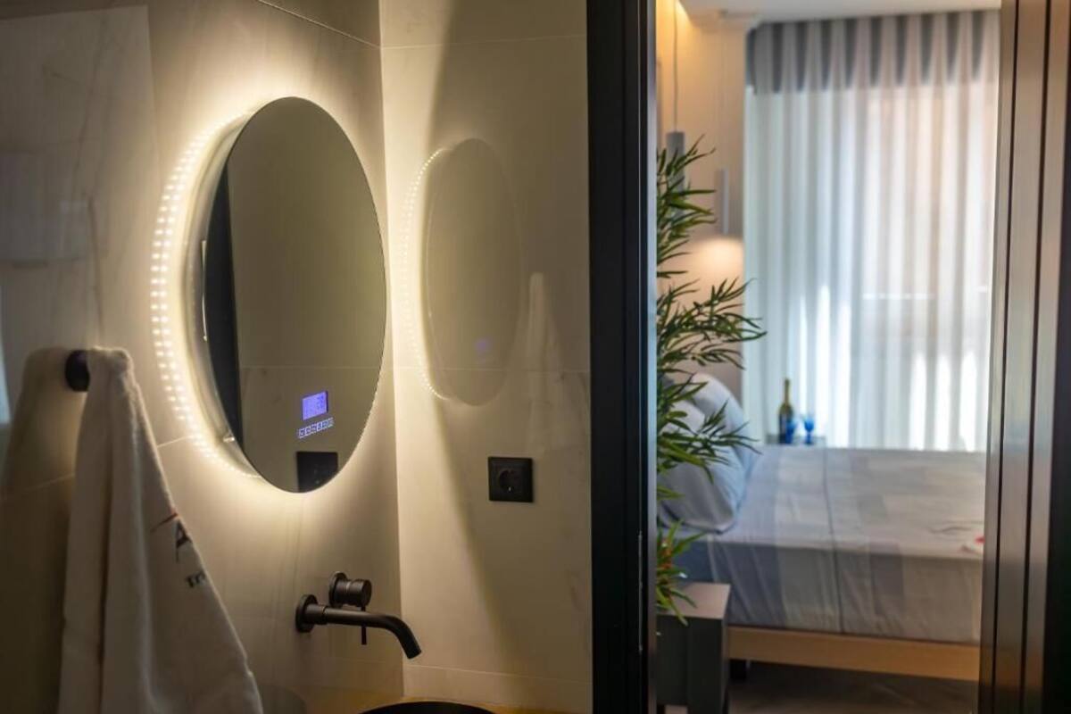 A modern bathroom with a large mirror, a towel rack, and a sink.