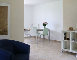 Relax in a comfortable seating area with a sofa, dining space, and bookshelf.