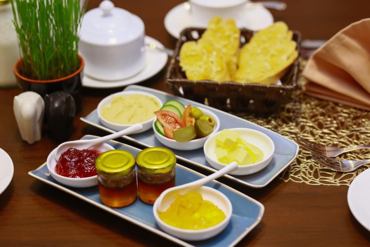A table set with various dishes including pickles, condiments, and bread.