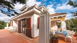 Una villa con un patio, un comedor y una planta en maceta.