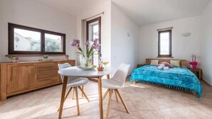 Un dormitorio con cama, mesita de noche, ventana y vistas al exterior.