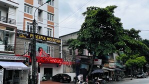 Ein mehrstöckiges Gebäude mit einem Schild für das Hotel "Peaceful Mountain".