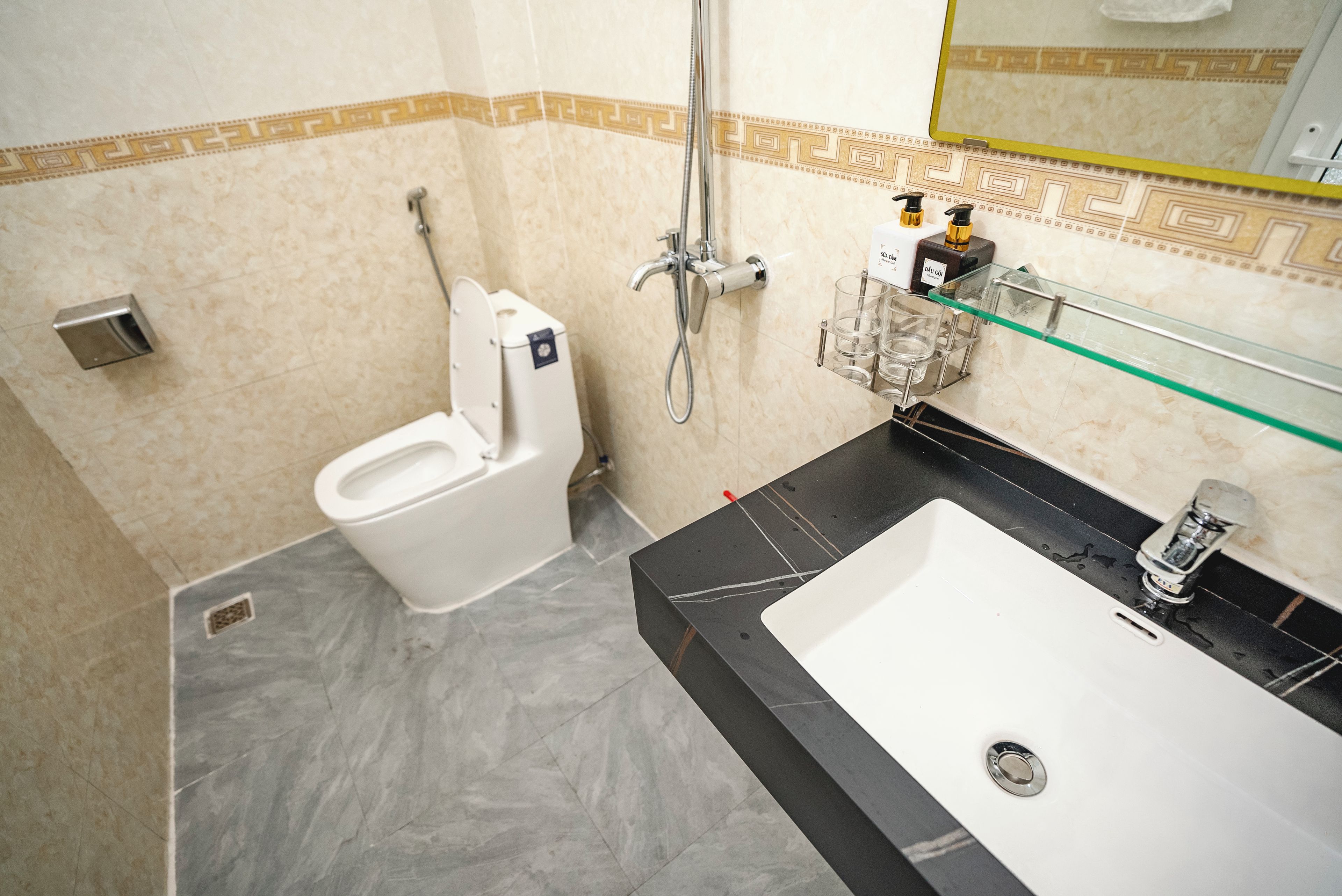 A bathroom with a toilet, a shower, and a sink.