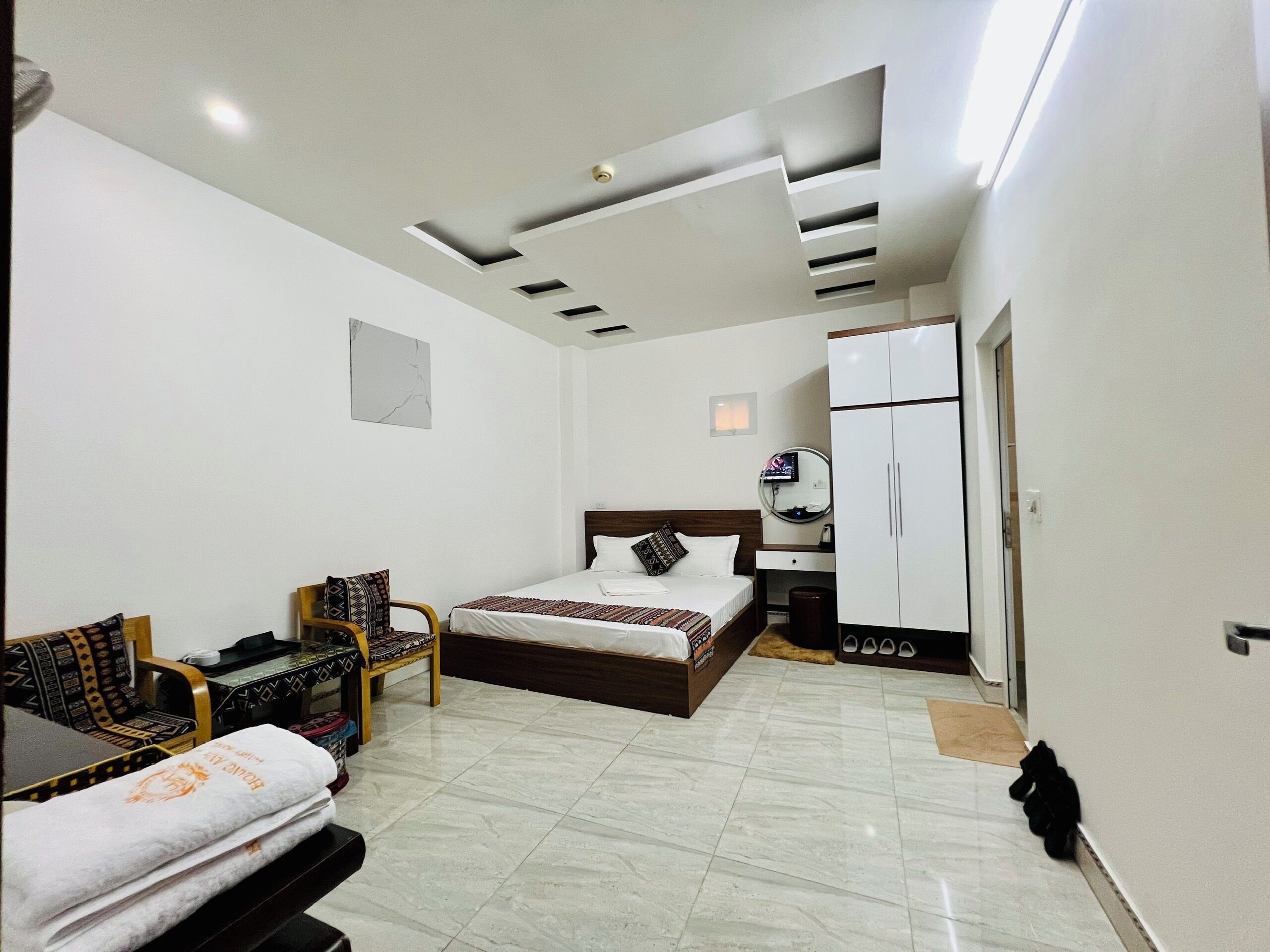 Habitación de hotel con cama, escritorio, silla, armario y baño.