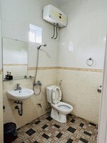 A bathroom with a toilet, sink, and shower.