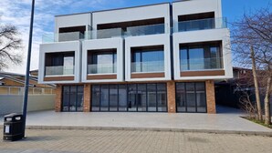 Un edificio moderno de varios pisos con amplias ventanas y techo plano.
