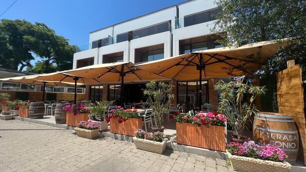 Un edificio moderno con asientos exteriores y jardineras con flores.