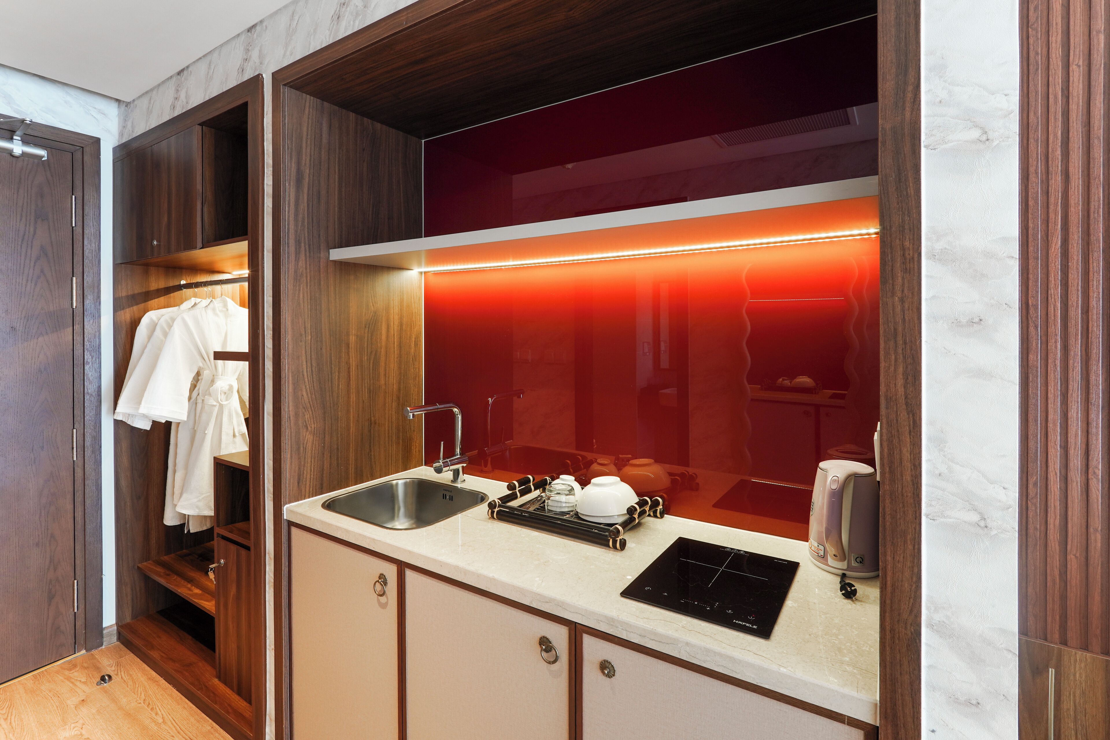 A modern kitchen with a built-in oven, a sink, and a coffee machine.