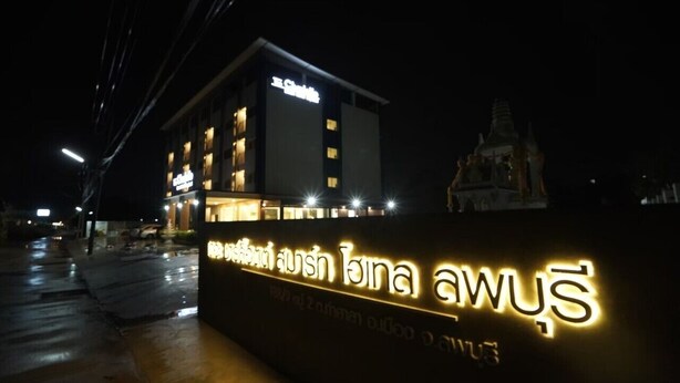Een gebouw met verlichte reclameborden, waaronder een opvallend bord met Thaise letters.