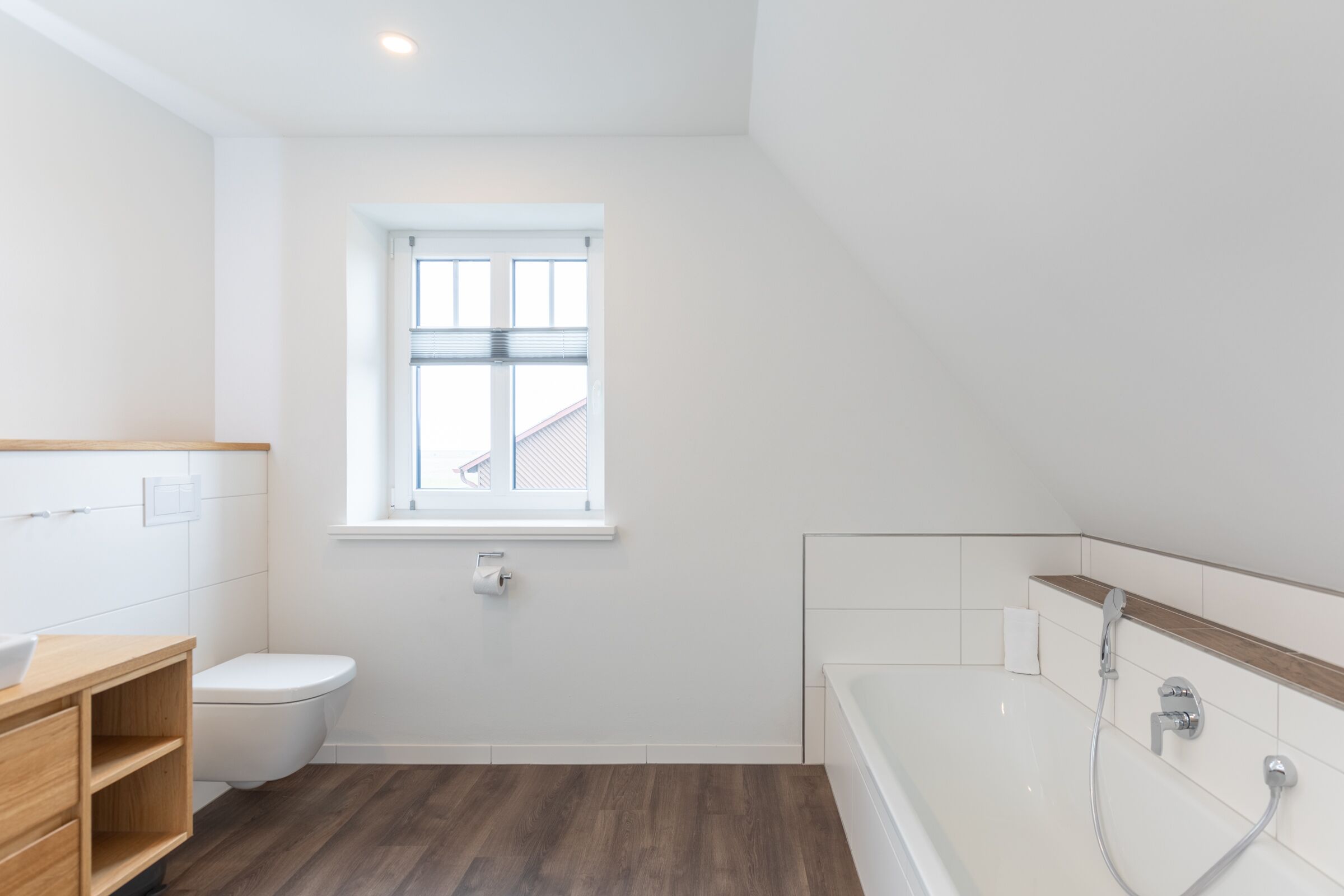 Ein modernes Badezimmer mit Toilette, Waschbecken und Badewanne.