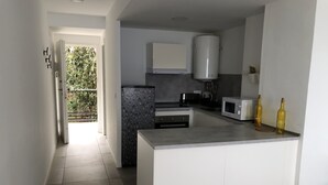 Una cocina moderna con una isla central, un microondas y dos botellas de vino sobre la encimera.