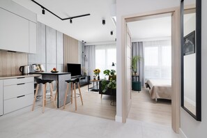 A modern apartment with a kitchen, dining area, and a bedroom. - EASY RENT Apartments- Kompozytorów 7.51 (Lublin)