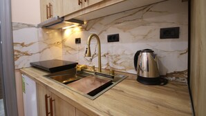 Uma cozinha com painel de mármore, eletrodomésticos de aço inoxidável e armários de madeira.
