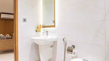 A modern bathroom with a toilet, sink, and shower.