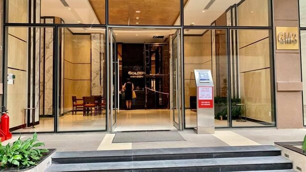 A hotel entrance with glass doors, a staircase leading up, and a sign for the hotel.