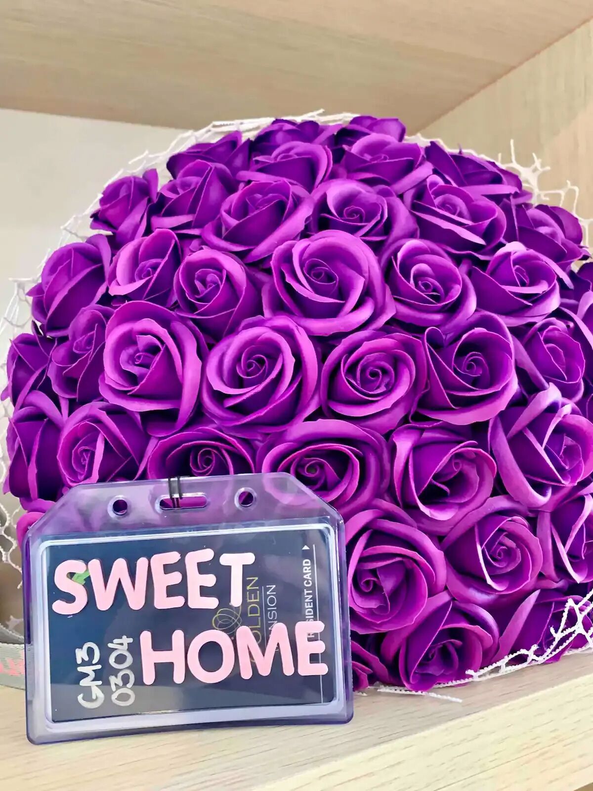 A bouquet of purple roses and a gift card labeled "SWEET HOME".