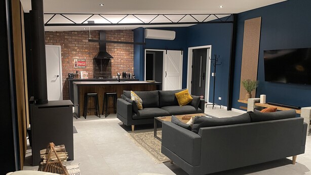 Een moderne woonkamer met een open haard, een bank en een salontafel.