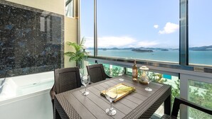 Un balcón con una mesa lista para dos personas, con vistas panorámicas al agua y a las islas.