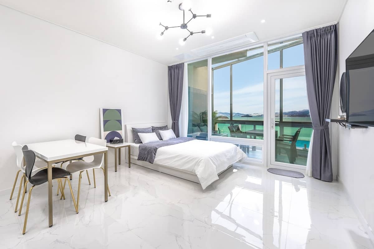 Een moderne slaapkamer met een bed, een bureau en een stoel.