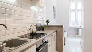 Une cuisine moderne avec des carreaux blancs, une cuisinière encastrée et une fenêtre donnant sur un beau paysage.