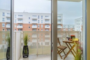 A balcony with a table, chairs, and potted plants. - Lumina modern studio with balcony (Łódź)
