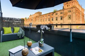 An outdoor seating area with a laptop, a magazine, and a vase of flowers. - Lumina stylish 2-level apart next to Księży Młyn (Lódz)
