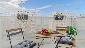 Un área de estar al aire libre con una mesa, sillas y un cuenco de frutas.