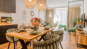 Een moderne eetruimte met een houten tafel, comfortabele stoelen en hangende rieten lampen.