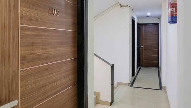 A hallway with a wooden door marked "402" and a tiled floor.